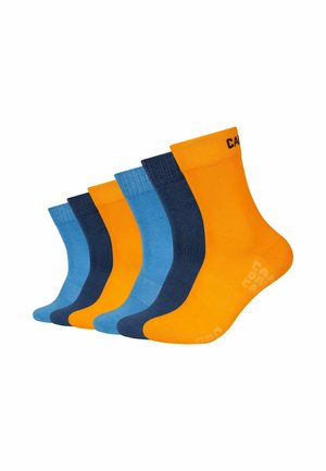Sechs Paare knielanger Socken in den abwechselnden Farben Gelb, Dunkelblau und Hellblau, diagonal auf einem weißen Hintergrund angeordnet.