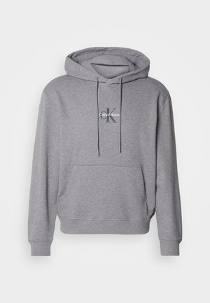 Hallhalli hall teine, mis on valmistatud puuvillasegistusest, funktsioneerib ees nagu kanguru tasku, kapuuts on nööriga reguleeritav ning rinnal on brodeeritud Calvin Kleini logo.