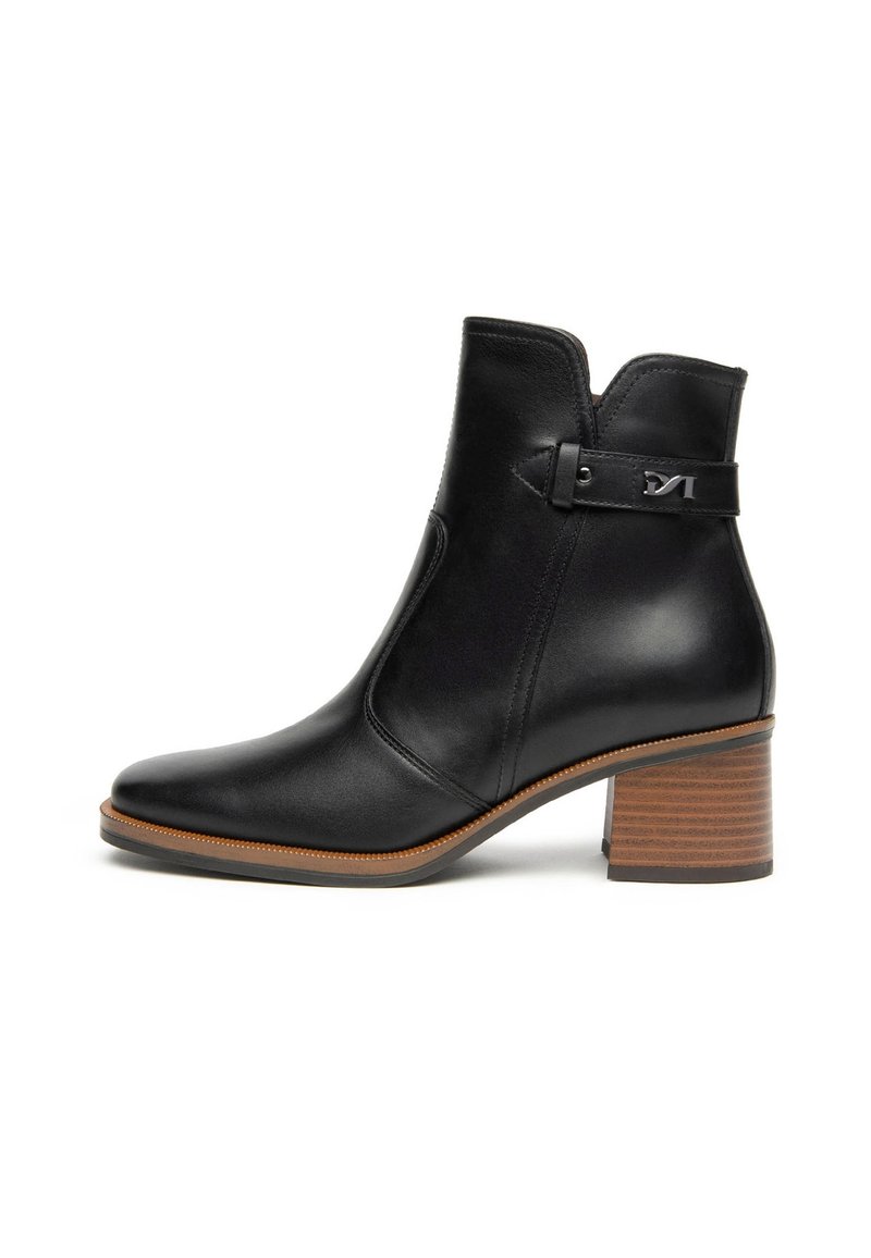 Schwarze Leder-Ankle Boots mit spitzer Zehe, seitlichem Elastikeinsatz und gestapeltem Absatz. Verfügt über einen Riemen und metallische Akzente an der Seite.