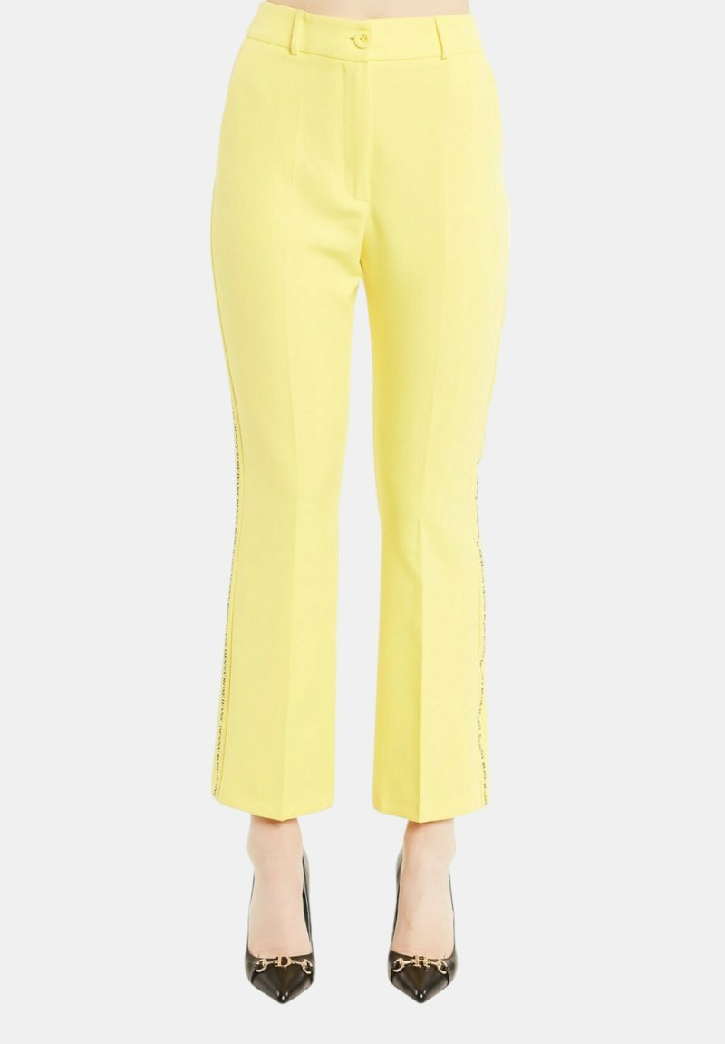 Pantaloni gialli su misura con gamba dritta e dettagli laterali discreti. Il tessuto ha una texture liscia e presenta una chiusura con bottone in vita.