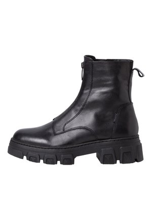Bottine en cuir noir avec semelle épaisse à crampons, fermeture éclair latérale et languette à l'arrière.