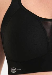 Top sportivo nero con pannelli in rete, tessuto texture e supporto con ferretto. Include etichetta con il marchio nella parte inferiore.