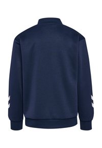 Veste bleu marine à manches longues avec col, poignets et bas côtelés, avec des bandes blanches inclinées sur les manches extérieures.