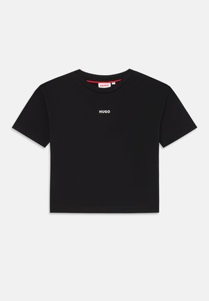 Juodas trumpas medvilninio audinio marškinėliai. Turi trumpas rankoves ir apvalų iškirpimą. Baltu spalva ant krūtinės atspausdintas "HUGO" logotipas.