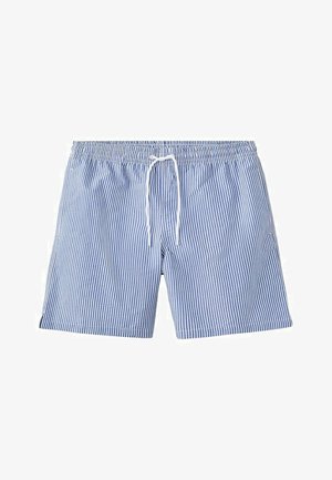 Shorts de bain à rayures verticales bleues et blanches avec taille élastique et cordon blanc, posés à plat sur un fond blanc.