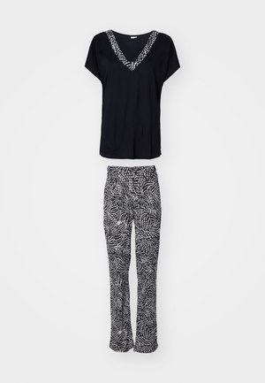 Black V-neck top with patterned trim, paired with black and white patterned flared pants, showcasing soft fabric and relaxed fit.