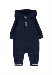 Granatowy kombinezon jednoczęściowy z kapturem, z prążkowanym materiałem, białym logo z przodu i paskowymi mankietami przy kostkach.