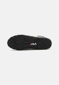 Soletta in gomma nera con design a rilievo e logo Fila bianco. Motivo testurizzato per migliorare la presa. Forma leggermente curvata.