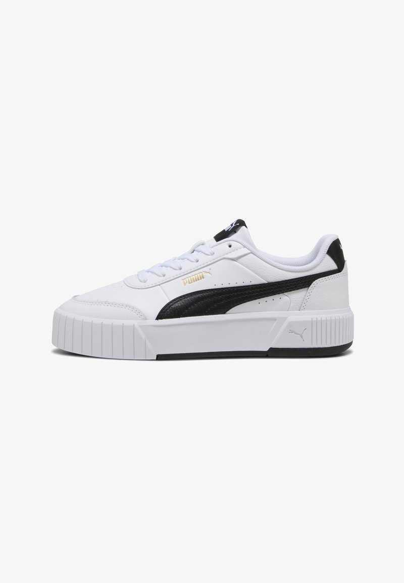 Baskets blanches à semelle épaisse, bande noire Puma, logo Puma doré, languette de talon noire, lacets blancs et perforations sur le côté.