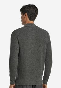 Grå stickad cardigan med en strukturerad design, långa ärmar och en nedvikt krage. Har sida slits och en avslappnad passform.