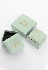 Des boîtes cadeaux vert menthe avec des lettres dorées, de forme carrée, en papier texturé et avec un intérieur noir. Une boîte est ouverte, révélant son intérieur.