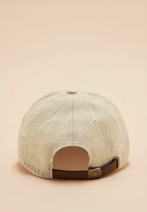 Casquette de baseball en lin beige avec sangle marron réglable et boucle en métal, vue de dos sur un fond beige clair.