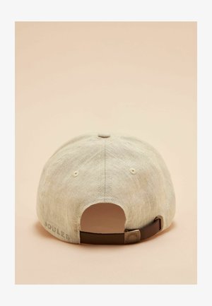 Casquette de baseball en lin beige avec sangle marron réglable et boucle en métal, vue de dos sur un fond beige clair.