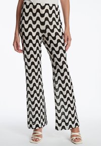 Zwart-witte broek met golvend patroon, gemaakt van een gestructureerde stof, met een flare-vorm en een hoge taille.