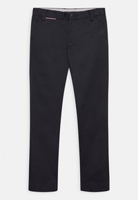 Svarta bomulls-chinos med en rak passform, utrustade med knappstängning framtill och en subtil röd detalj vid fickan. Slät textur.