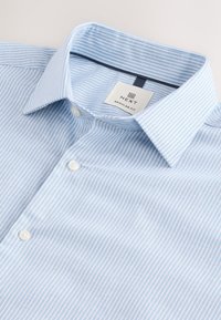 Camicia a righe azzurro chiaro con vestibilità regolare, dotata di colletto button-down e bottoni bianchi, realizzata in tessuto liscio. Include un'etichetta del marchio.