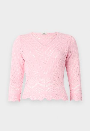 Roza pletena veste s V-izrezom, rukavima do 3/4 i valovitim rubom. Sadrži složen uzorak čipke s geometrijskim dizajnom.