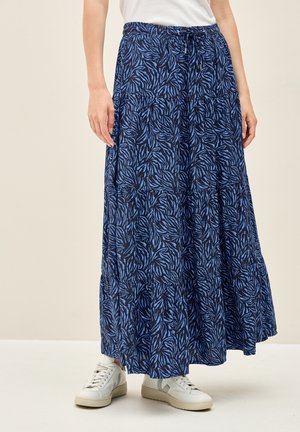Blue and navy floral-patterned maxi skirt with a tiered design and elastic waistband, paired with white sneakers.