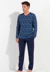 Camicia blu navy a maniche lunghe con un motivo astratto blu chiaro, abbinata a pantaloni blu navy uniti. Il tessuto sembra liscio e leggero.