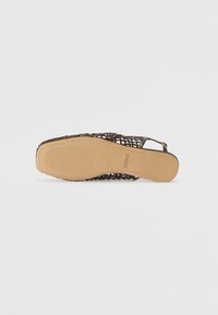 Sandalia slingback trenzada marrón con suela texturizada, que presenta un tacón bajo y una correa ajustable, diseñada para la transpirabilidad y la comodidad.