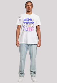 White cotton t-shirt featuring colorful graphic design with the text "mong mong" and cartoon-like food illustrations, paired with light blue jeans.
