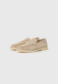 Beige Wildleder Slipper mit runder Zehenform, dezenten Stickdetails und einer weichen, flexiblen Gummisohle. Mit einem unkomplizierten Schlupfdesign.
