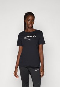 Svart bomull T-skjorte med "SPURS" logo og Nike-emblem. Klassisk crew-neck design med korte ermer og en avslappet passform.