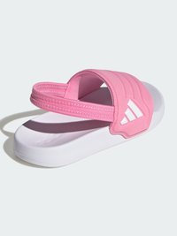 Ροζ σανδάλι με σόλα από μαλακό καουτσούκ, λευκή εξωτερική σόλα και υφασμένες λουράκια με το λογότυπο τριών ραβδώσεων στη πλευρ�ά.