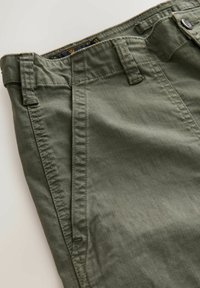 Olive green cotton pants with belt loops, angled front pockets, visible stitching, and a button closure at the waistband.