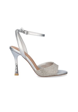 Sandalia plateada de tacón alto con tira en el tobillo y punta abierta cubierta de piedras de imitación, con un fino tacón de aguja de 7,5 cm.