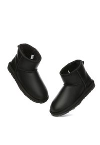 Schwarze Lederknöchelstiefel mit weichem Innenfutter, runder Zehenform und minimalem Steppdetail. Gummisohle mit strukturiertem Grip.