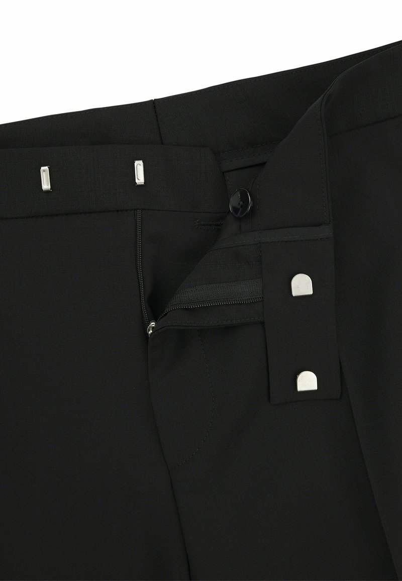 Schwarze Hose mit glatter Textur, Reißverschluss und fünf Metallverschlüssen am Bund. Akzente sind ein Druckknopfverschluss und eine seitliche Tasche.