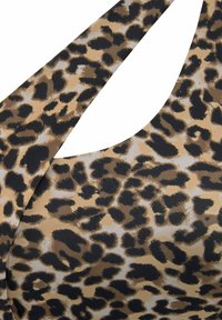 Haut à imprimé léopard avec un mélange de couleurs beige et noir, à la texture lisse et des bretelles larges au design courbé.
