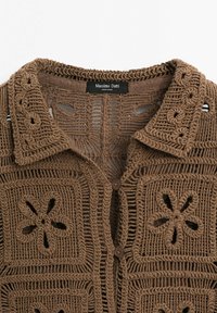 Cardigan marron en crochet avec motifs carrés floraux, fermeture à boutons et col replié, étiquette Massimo Dutti.