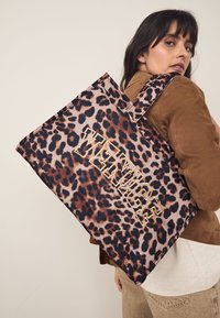 Geantă de umăr cu imprimeu leopard și text auriu "VENICE". Fabricată din material textil, prevăzută cu cusături rezistente, mânere mari și un design spațios.