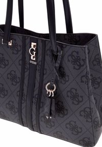Bolsa tote negra con el logo de GUESS en plateado, tejido texturizado, un patrón de diamantes y asas duales con un adorno desmontable.