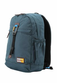 Mochila de tejido verde oscuro con un compartimento principal amplio, bolsillo exterior, acentos de cuero marrón y correas ajustables.