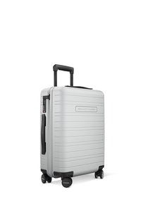 Silver hard-shell suitcase with horizontal ridges, retractable black handle, four black wheels, and integrated combination lock.