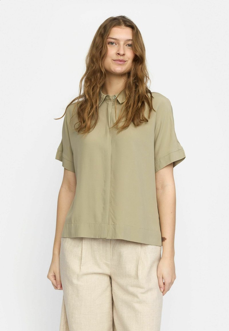Short-sleeve, collared shirt in olive green, featuring a button-down front and a loose, relaxed fit. Smooth, lightweight fabric.