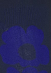 Tissu à motifs marins présentant de grands motifs floraux bleu foncé avec des zones texturées. Le matériau a une apparence lisse et tissée.