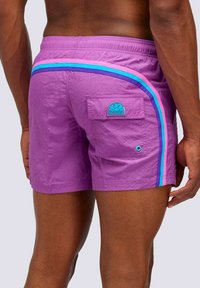 Costumi da bagno viola con una striscia laterale in rosa, blu e viola. Include una tasca sul retro con un'etichetta blu. Tessuto testurizzato.