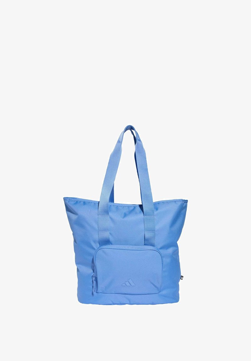 Blue tote bag made from durable fabric, featuring two wide handles, a front zip pocket, and a subtle logo on the front.