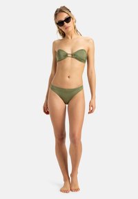 Olivinių atspalvių bikini komplektas, kuriame yra besijungiantis viršus su sukimšiu priekyje ir auksiniu žiedu, derinamas su atitinkamais žemais apatiniais. Lygus paviršius.