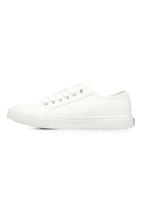 Des baskets blanches en toile présentent un bout arrondi, six œillets métalliques et une semelle en caoutchouc texturé. Design minimaliste, adapté à une tenue décontractée.