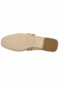 Suela de zapato de cuero beige con un acabado suave, ligeramente elevada en el talón, y un detalle de costura intrincada cerca de las correas. Talón de goma plano para mayor agarre.