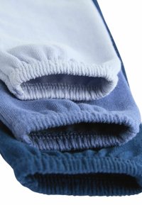 Trīs zeķu pāri dažādās zils nokrāsās. Materiāls ir mīksts trikotāža, ar savelkošām elastīgām atverēm un gludu tekstūru.