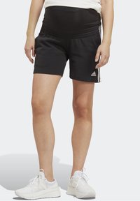 Svarta idrottsshorts med ett elastiskt midjeband, som har tre vita ränder på sidorna och en Adidas-logga på den nedre fållen.