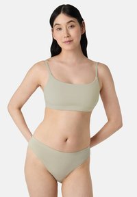Svetle zelená souprava spodního prádla obsahující bezešvou podprsenku s tenkými ramínky a odpovídající bikiny. Měkká, elastická látka.