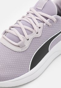 Lila mesh-sneakers med ljuslila snören, kontrasterande svart sidostrok, vadderad krage och texturerad yta för grepp.