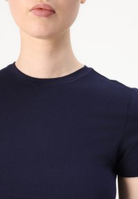 Marineblå tettsittende t-skjorte med rund hals og korte ermer, laget av glatt bomullsstoff, med et rent og enkelt design.